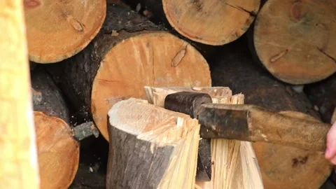 A man is chopping logs with an axe on chopping block. Harvesting of firewood Stock Footage 225537703