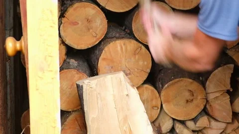 A man is chopping logs with an axe on chopping block. Harvesting of firewood Stock Footage 229806738