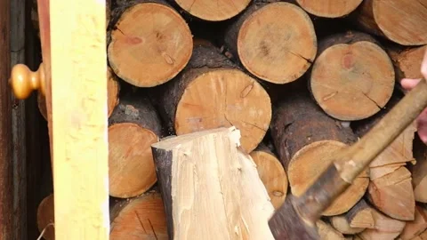 A man is chopping logs with an axe on chopping block. Harvesting of firewood Stock Footage 231512806