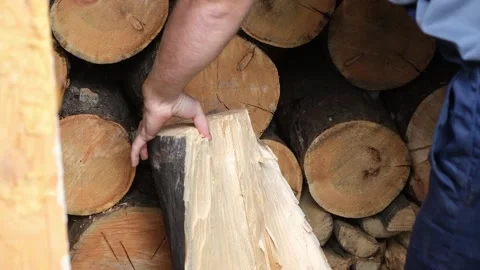 A man is chopping logs with an axe on chopping block. Harvesting of firewood Stock Footage 232803970