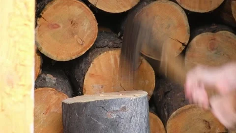A man is chopping logs with an axe on chopping block. Harvesting of firewood Stock Footage 233296245