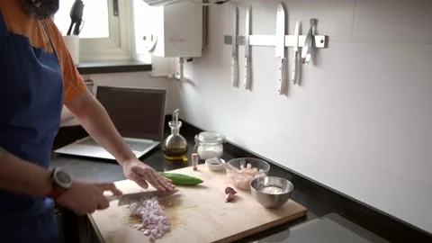 Man chopping onions while learn to cook Stock-Footage 136410487