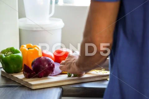 Man Chopping Vegetables At Kitchen Counter