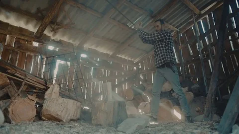 Man chopping wood inside the barn with beautiful sun rays light Stock Footage 82715522
