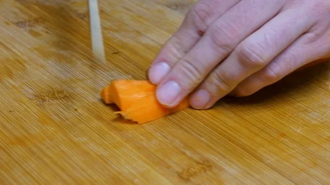 The man chops the carrot. Close shot of a carrot. 4K Stock Footage 128593364