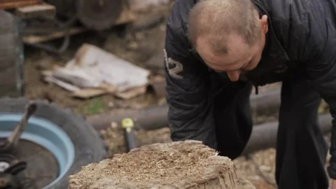 A man chops firewood with a sharp ax Stock Footage 259559050