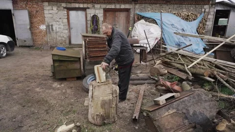 A man chops firewood with a sharp ax Stock Footage 259814996