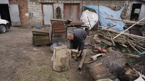 A man chops firewood with a sharp ax Stock Footage 259815200