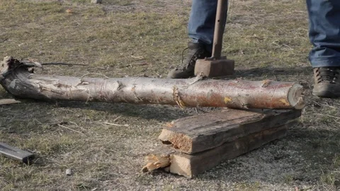 Man chops firewood using sledgehammers Stock Footage 74685977