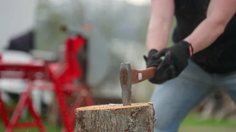 A Man Chops a Log With an Axe, Splitting... | Stock Video | Pond5