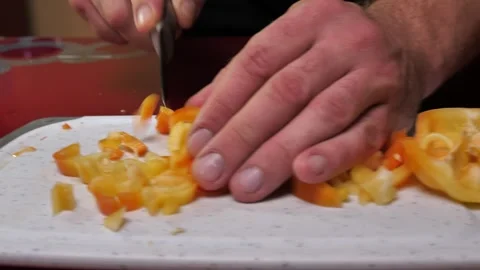 A man chops a yellow pepper into pieces on a chopping board close-up 스톡 동영상 255288174