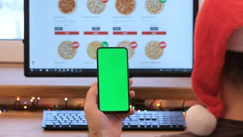 A man in a Christmas hat orders pizza. Pizza. a man in his office holds a Stock Footage 182688819