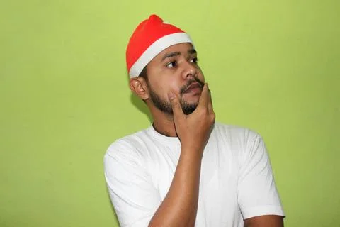Man with christmas hat thinking Stock Photos