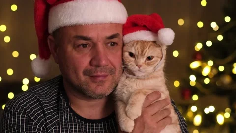 Man in Christmas time holding red Scottish fold cat in Santa hat Stock-Footage 221662498