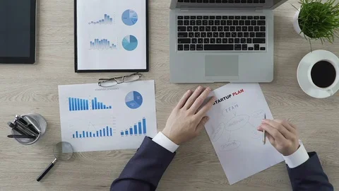 Man circling key elements of startup plan on piece of paper, successful business Stock Footage 76766515