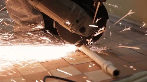 Man with circular saw cuts an old pipe on tiled floor. Stock Footage 83028634