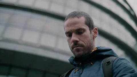Man in city looking down and frowning Stock Footage 130981270