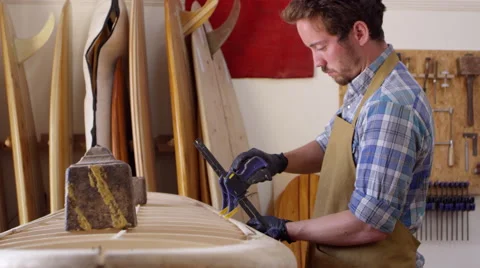 Man Clamping Custom Surfboard In Workshop Shot On RED Camera Stock Footage 64349278