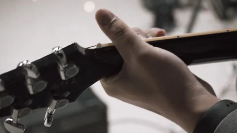 A man clamps the strings on a guitar Stock Footage 131567042