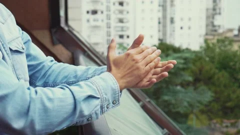 Man clapping on the balcony to support the mediacal staff during the coronavirus 스톡 동영상 130400228