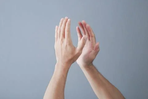 Man clapping hands on grey background Stock Photos