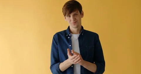 A man claps his hands, applause on a yellow background Stock Footage 125284873