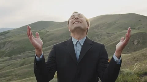 A man in a classic suit, against the backdrop of nature and the rays of the sun Stock Footage 258480217