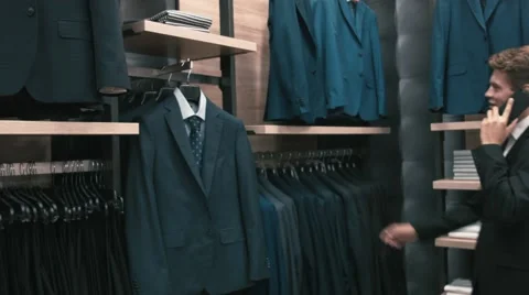 A man in a classic suit talking on a cell phone in shop Stock Footage 66428140