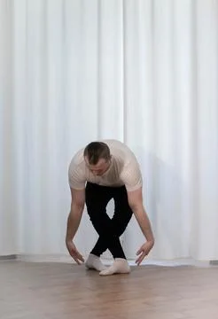 A man in a classical ballet dance pose. Dance training for home. A young an.. Stock Photos