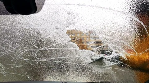 Man clean up car window of ice with scrapper Video stock 141842747