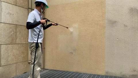 A man clean a dirty wall with the high pressure cle Stock Footage 138571030