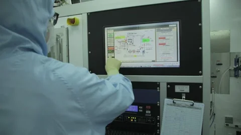 Man in a clean room suit operating a Touch screen Stock Footage 61003381