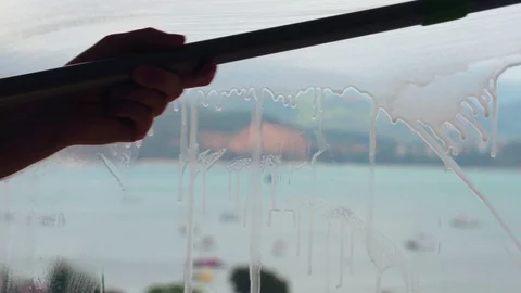 Close-up Of Man's Hand Cleaning The Car Window By Squeegee Stock