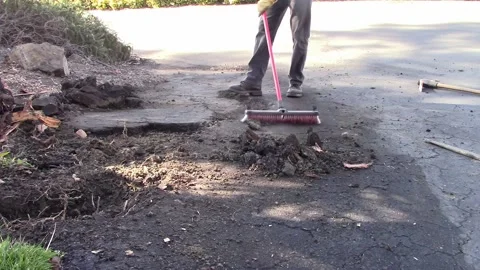 Man Cleaning Asphalt Construction with Broom Stock Footage 222802641