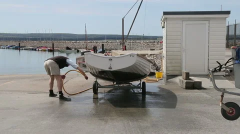 Man cleaning athe bottom of a sailing dinghy Stock Footage 51255691