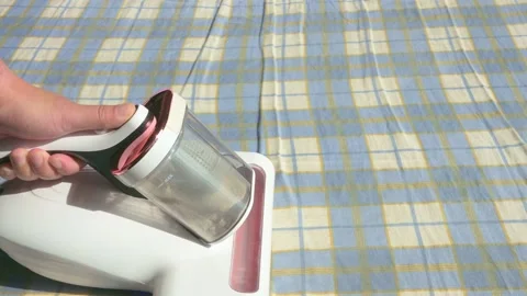 A man cleaning the bed cover with a mite remover Stock Footage 312180955