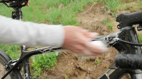 Man cleaning bicycle with soap foam and washcloth. Bike washing. Man washes bike Stock Footage 154175911