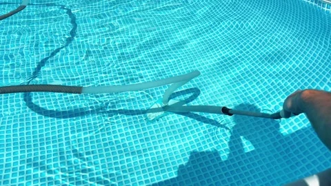 Man Cleaning Bottom of Backyard Swimming Pool with Vacuum Head and Hose Stock Footage 339006102