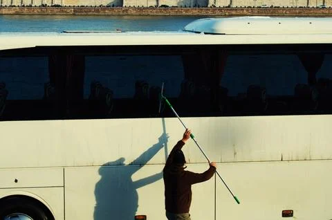 A man cleaning a bus with a squeegee Stock Photos