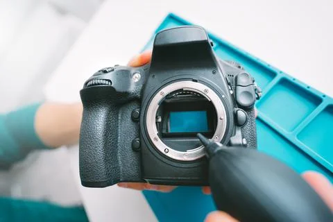 Man cleaning camera sensor with dust cleaner, air blower or vacuum pump. Stock Photos