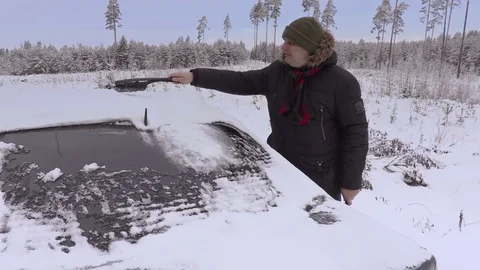 Man cleaning car with brush in winter Stock Footage