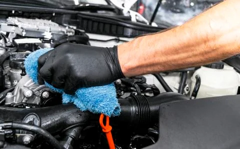 A man cleaning car engine with microfiber cloth. Car detailing or valeting co Stock Photos