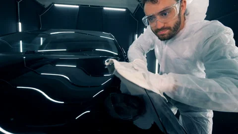 Man cleaning a car in a garage, close up. Stock Footage