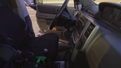 Man cleaning car interior and spraying with disinfection liquid Stock Footage 127595981
