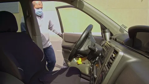 Man cleaning car interior and spraying with disinfection liquid Stockbeeldmateriaal 127596062