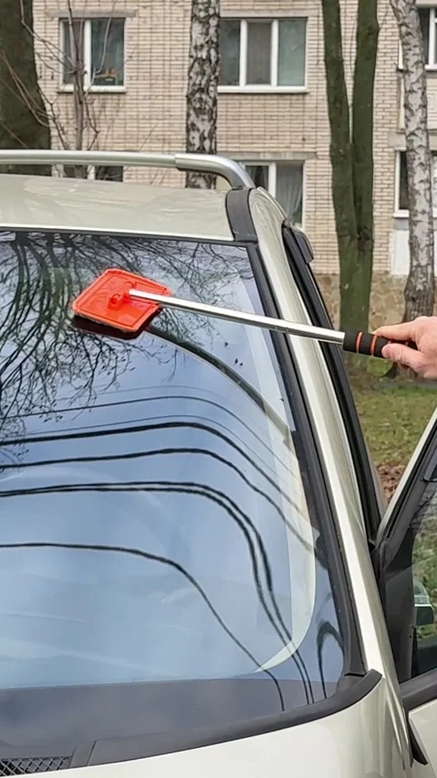Man Cleaning Car Windshield with Brush Stock Footage 323513150