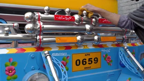 Man cleaning a chrome front bumper of a Pakistani Jingle Truck Stock Footage 132927273