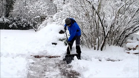 Man cleaning deep snow with shovel Stock Footage 100657579