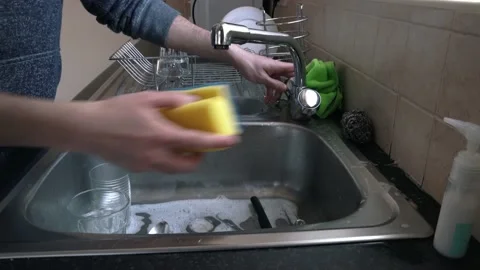 Man cleaning dish with sponge Stock Footage