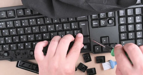 A man cleaning dust that has collected under keys Stock Footage 94381835